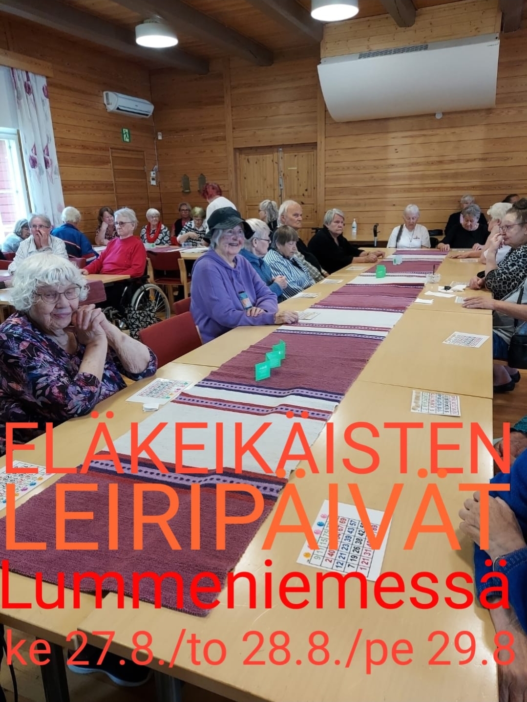 Eläkeikäisten leiripäivä, perjantai Eläkeikäisiä Lummeniemessä juhlasalissa pöytien äärellä.