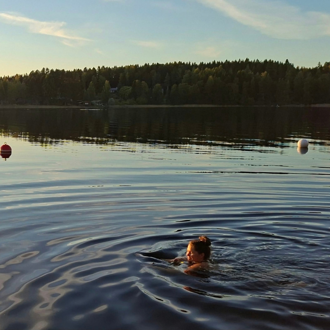 Nainen ui järvessä.