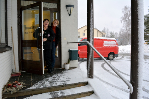 Ansa Litendahl ja Anneli Palonen kurkkivat diakoniatoimiston ovesta, joka on seurakuntatalon päädyssä.